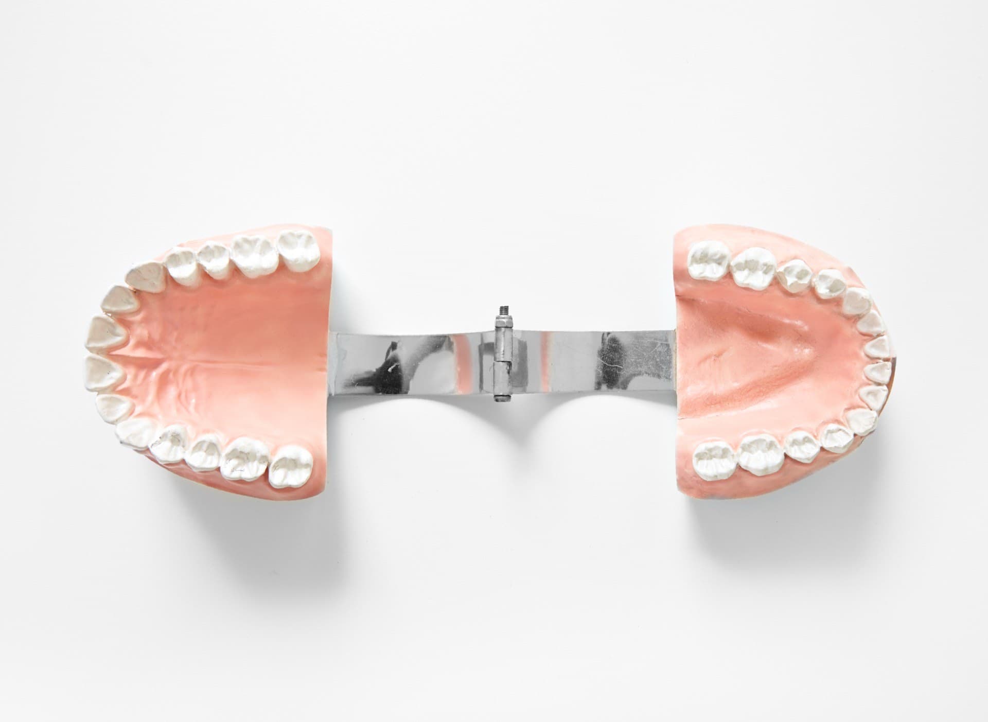 Upper and lower dental study models joined by a metal articulator