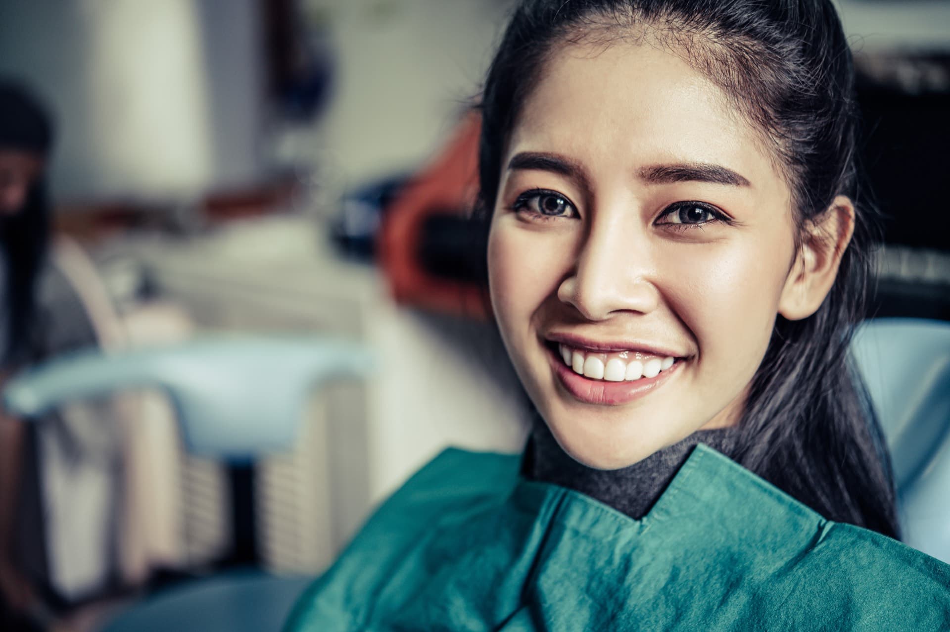 Dentist examining a patient's teeth under a treatment light
